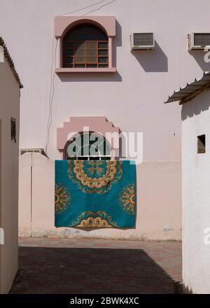 Tapis sur un mur séchant au soleil, Muscat, Sultanat d'Oman. Banque D'Images