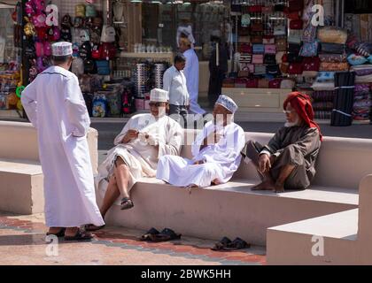 Groupe de vieux hommes locaux assis sur un banc dans le Souq de Mutrah, Muscat, Sultanat d'Oman. Banque D'Images