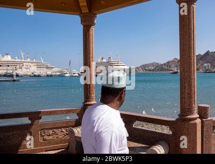 Homme omanais local debout dans le pavillon sur la Corniche de Mutrah, Muscat, Sultanat d'Oman. Banque D'Images