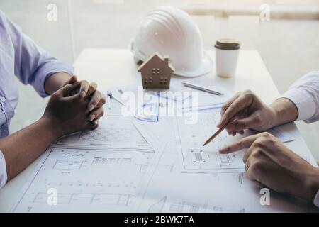 Discussion entre l'architecte d'équipe ou le personnel technique travaillant ensemble sur une table sur un chantier de construction. Banque D'Images