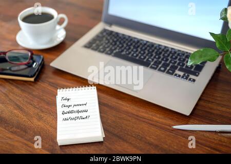 Bloc-notes papier avec texte changer le mot de passe, sur un bureau en bois avec ordinateur portable, café et lunettes, sécurité concept d'affaires, sélection de focus, très Banque D'Images