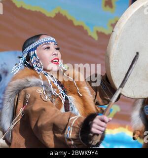 Femme en vêtements nationaux habitants autochtones Kamchatka dansant avec tambourine. Concert, célébration nationale de vacances Koryak jour de Seal Hololo Banque D'Images