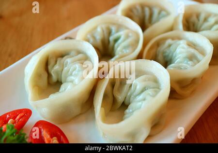 Fermer une assiette de boulettes de mandu vapeur ou de raviolis coréens servies sur une table en bois Banque D'Images