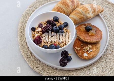 plateau de petit déjeuner sain et nutritif avec granola, crêpes à l'avoine et croissants. Composition horizontale Banque D'Images