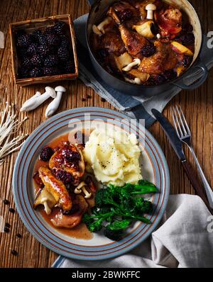 Faisan braisé traditionnel britannique avec baies et champignons, repas maison servi avec purée de pommes de terre et brocoli tendre Banque D'Images