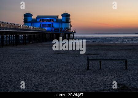 Weston-Super-Mare, Angleterre, Royaume-Uni - 31 mai 2020 : le soleil se couche derrière le Grand Pier moderne de Wester-Super-Mare, avec le sud du pays de Galles au loin derrière le Banque D'Images