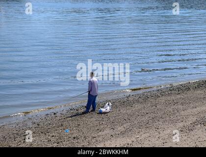 Homme local pêche sur la plage de Mutrah, Muscat, Oman Banque D'Images