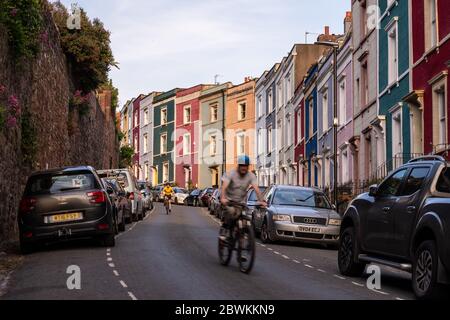 Bristol, Angleterre, Royaume-Uni - 9 mai 2020 : deux cyclistes se trouvent à proximité de maisons en terrasse colorées sur une colline escarpée à Hotwells, Bristol. Banque D'Images