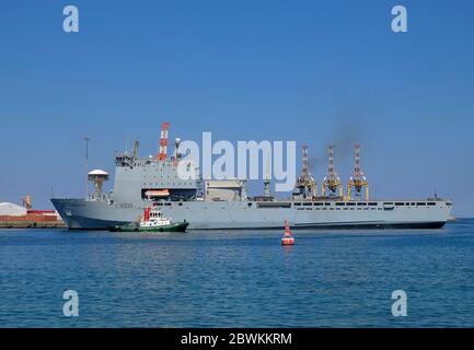 RFA Cardigan Bay étant tiré dans Port Sultan Qaboos par bateau à remorqueurs, Muscat, Oman Banque D'Images