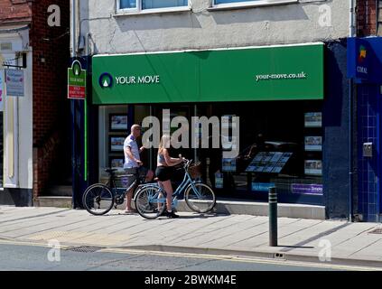 Cycliste regardant les maisons à vendre dans la fenêtre de votre déménagement agents immobiliers, Goole, East Yorkshire, Angleterre Royaume-Uni Banque D'Images