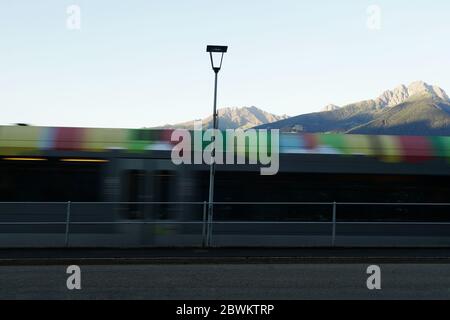 Train régional coloré flou en mouvement, Merano, Alto Adige, Italie. Banque D'Images