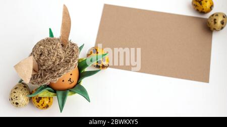 Lapin fait main maison posé sur un stand entouré de feuilles vertes, naturel, vue de dessus Banque D'Images