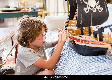 garçon de 6 ans jouant avec un bateau pirate à la maison Banque D'Images