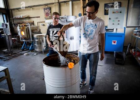 Un étudiant reçoit des cours lors d'une leçon de soufflage de verre à l'atelier Berlin Glas à Wedding, Berlin, Allemagne Banque D'Images