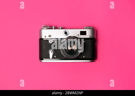 Caméra rétro isolée sur fond rose vif. Concept pop art. Pose à plat, style minimaliste Banque D'Images