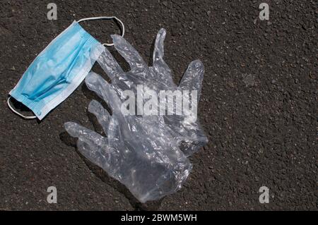 Masque chirurgical et gants jetables utilisés pendant la pandémie du virus Corona déversés sur un trottoir de rue en Suisse. Banque D'Images