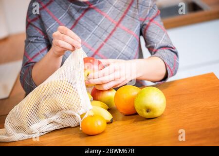 Packs ECO. Une femme sort des fruits après avoir fait ses achats dans un sac Eco. Sacs anti-plastique. Zéro déchet. Banque D'Images