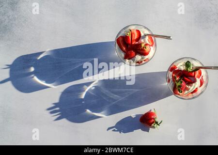 Dessert d'été avec crème mascarpone et fraises dans une lumière dure, tiré d'en haut Banque D'Images