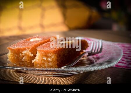 Turc dessert sambali, sambaba ou sam tatlisi servi dans une assiette avec fourchette et couteau sur table brune. Banque D'Images