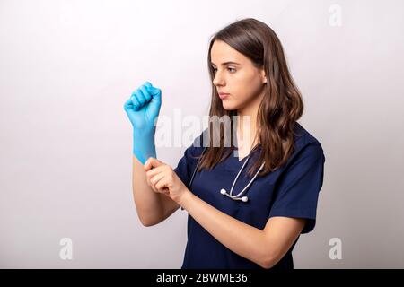 Un jeune volontaire met des gants chirurgicaux. Banque D'Images