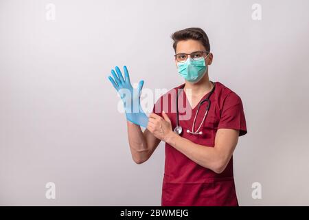 Un jeune volontaire met des gants chirurgicaux. Banque D'Images