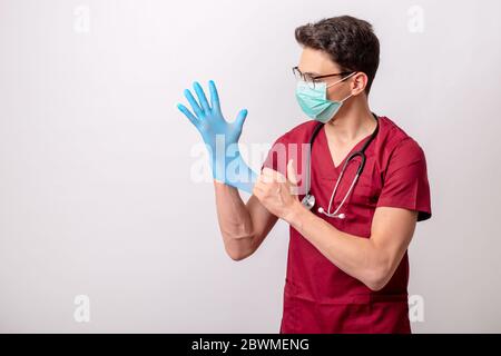 Un jeune volontaire met des gants chirurgicaux. Banque D'Images