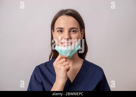 Le jeune médecin qui a pris son masque et qui souriait parce que la pandémie du coronavirus a été vaincue Banque D'Images