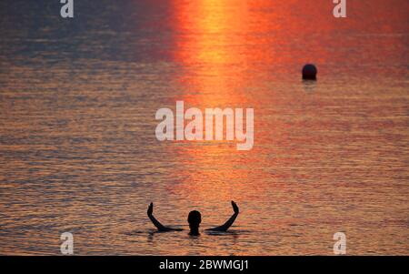 Les membres du public apprécient le soleil se lever à la baie d'Helen, dans Co. En bas de l'Irlande du Nord, alors qu'ils prennent un plongeon dans la mer d'Irlande. Credit: Jonathan porter/Alay Live News Banque D'Images