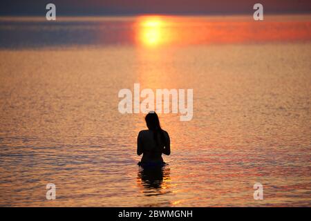 Les membres du public apprécient le soleil se lever à la baie d'Helen, dans Co. En bas de l'Irlande du Nord, alors qu'ils prennent un plongeon dans la mer d'Irlande. Credit: Jonathan porter/Alay Live News Banque D'Images