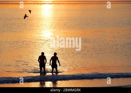 Les membres du public apprécient le soleil se lever à la baie d'Helen, dans Co. En bas de l'Irlande du Nord, alors qu'ils prennent un plongeon dans la mer d'Irlande. Credit: Jonathan porter/Alay Live News Banque D'Images