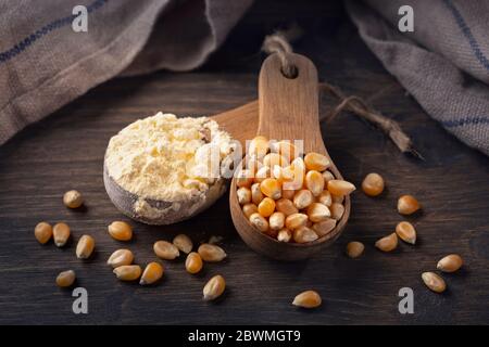Farine de maïs dans une cuillère en bois, sur fond de bois Banque D'Images