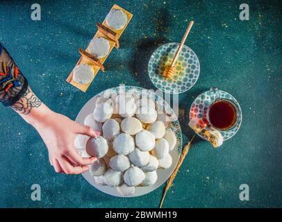 La main de femme prend le cookie sur la table avec du thé et du miel Banque D'Images