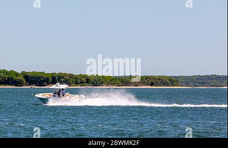 Deux gars sur un bateau à moteur hors-bord au large de Shelter Island, NY Banque D'Images