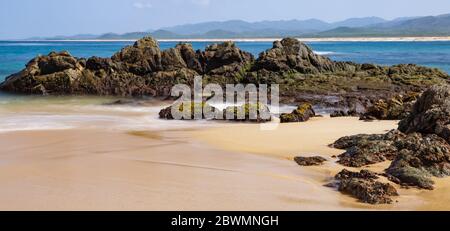 Le beau sable humide et les rochers couverts d'algues. Playa Mayto à Jalisco, Mexique. Banque D'Images