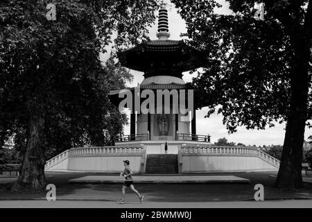 Peace Pagode à Battersea Park Londres avec coureur en premier plan en noir et blanc Banque D'Images