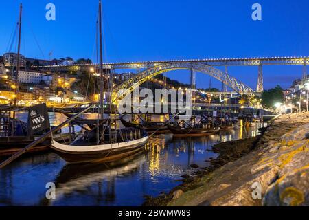 Pont Dom Luis de nuit de Vila Nova de Gaia avec les bateaux-ports Rabelo, les bateaux-cargo portugais en bois amarrés sur le fleuve Douro et la Ribeira AR Banque D'Images