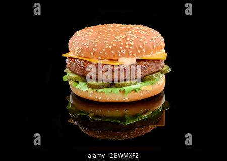 Grand hamburger ou cheeseburger savoureux sur fond noir Banque D'Images