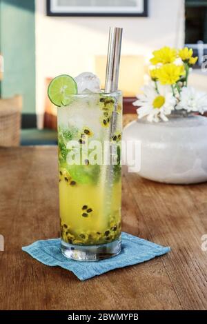 Cocktail de mojito de fruits de la passion avec paille de métal sur table en bois dans le café. Banque D'Images