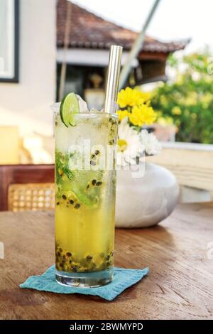 Cocktail de mojito de fruits de la passion avec paille de métal sur table en bois dans le café. Banque D'Images