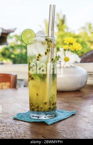 Cocktail de mojito de fruits de la passion avec paille de métal sur table en bois dans le café. Banque D'Images