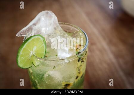 Cocktail mojito de fruits de la passion avec paille de métal sur table en bois dans le café de gros plan Banque D'Images