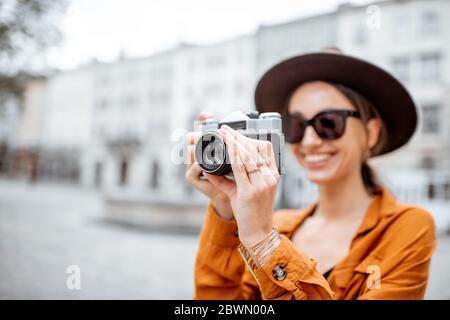 Portrait d'une jeune femme élégante avec photo-caméra voyageant dans la vieille ville. Concept de voyage heureux et vacances d'été dans la ville européenne Banque D'Images