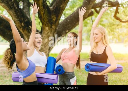 Cours de yoga en plein air, Groupe de jeunes femmes en bonne santé adolescentes Réunion heureuse de salutation ensemble pour l'exercice. Banque D'Images