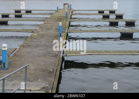 Marina de yacht hors saison en hiver et crise de coronavirus avec des jetées vides attendant un meilleur printemps et des bateaux dans l'eau froide de mer Banque D'Images