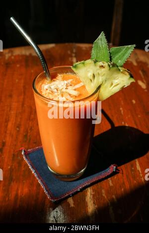 Smoothie papaye en verre sur table dans un café tropical Banque D'Images