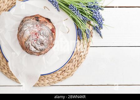 Gâteau de Pâques sur l'assiette et fleurs sur fond de bois Banque D'Images