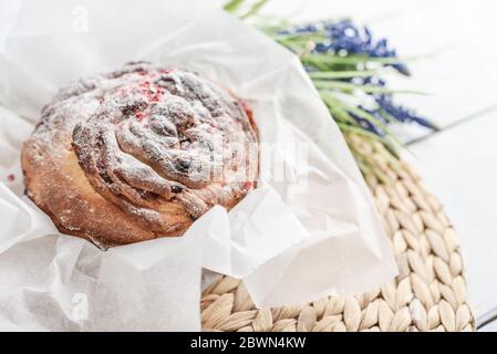 Gâteau de Pâques sur l'assiette et fleurs sur fond de bois Banque D'Images