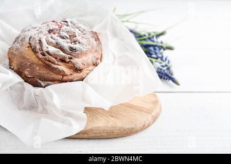 Gâteau de Pâques sur l'assiette et fleurs sur fond de bois Banque D'Images