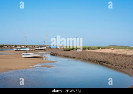 Norfolk Coast UK, vue en été des bateaux dispersés le long d'une crique près du village côtier de North Norfolk à Blakeney, Angleterre, Royaume-Uni. Banque D'Images