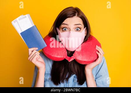 Portrait de l'étudiant choqué fille tenir des billets impressionné bordure fermé vêtements denim Jean chemise médical masque voyage cou coussin isolé sur lumineux Banque D'Images